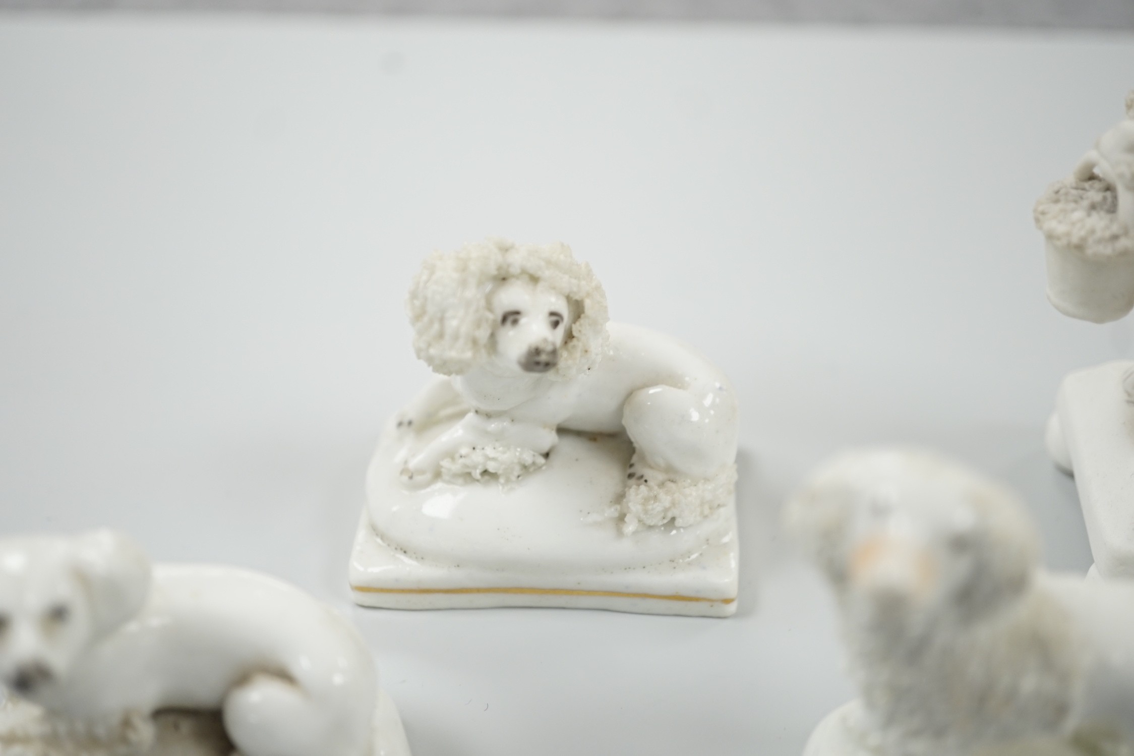 Five small Staffordshire models of poodles, together with a small poodle lying recumbent on an oval mounted base, possibly Davenport, c.1830-50, (6). Tallest 6.8cm., Provence: Dennis G. Rice collection, Cf. Dennis G.Rice
